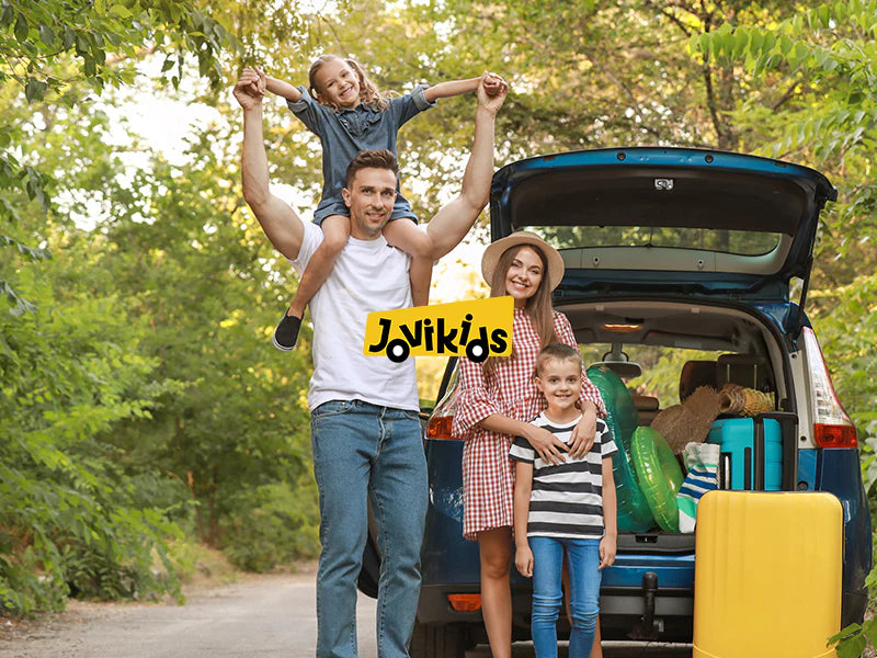Family with children standing by an open car trunk in a forest, with 'Jovikids' logo.